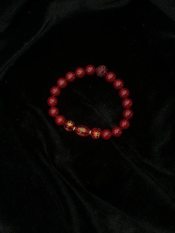 Red beaded bracelet on a black textured fabric background